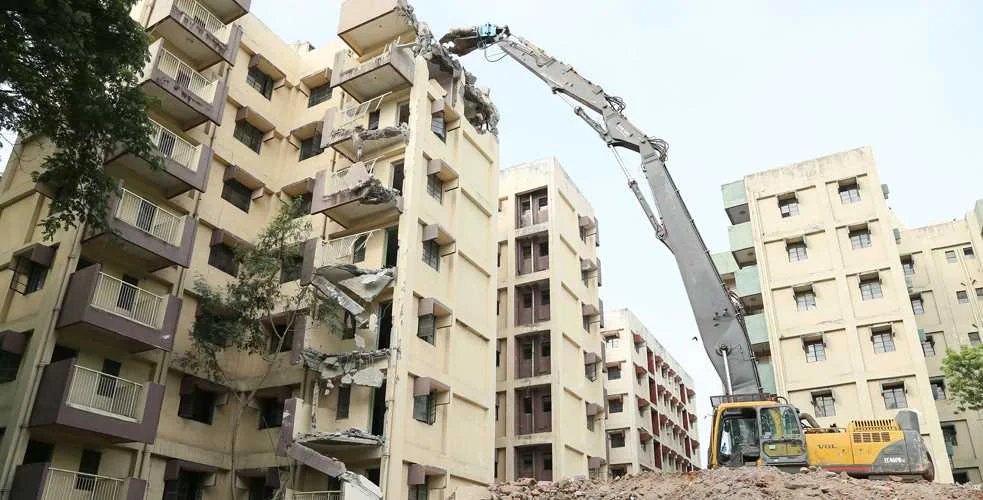 Excavator working on a multi-storey apartment demolition site