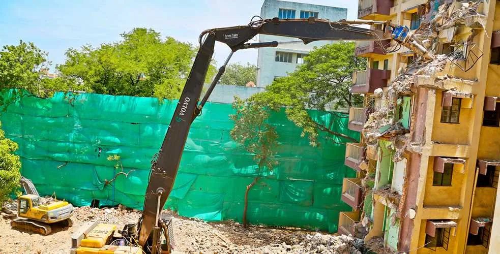 Large excavator operating on a rubble-covered demolition site