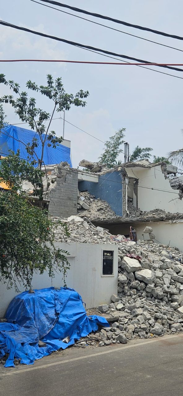 Partially demolished house with debris piled outside